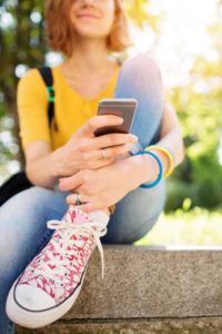 Nuori tyttö käyttää älypuhelinta, Kesäduunari-infoon liittyvä kuva